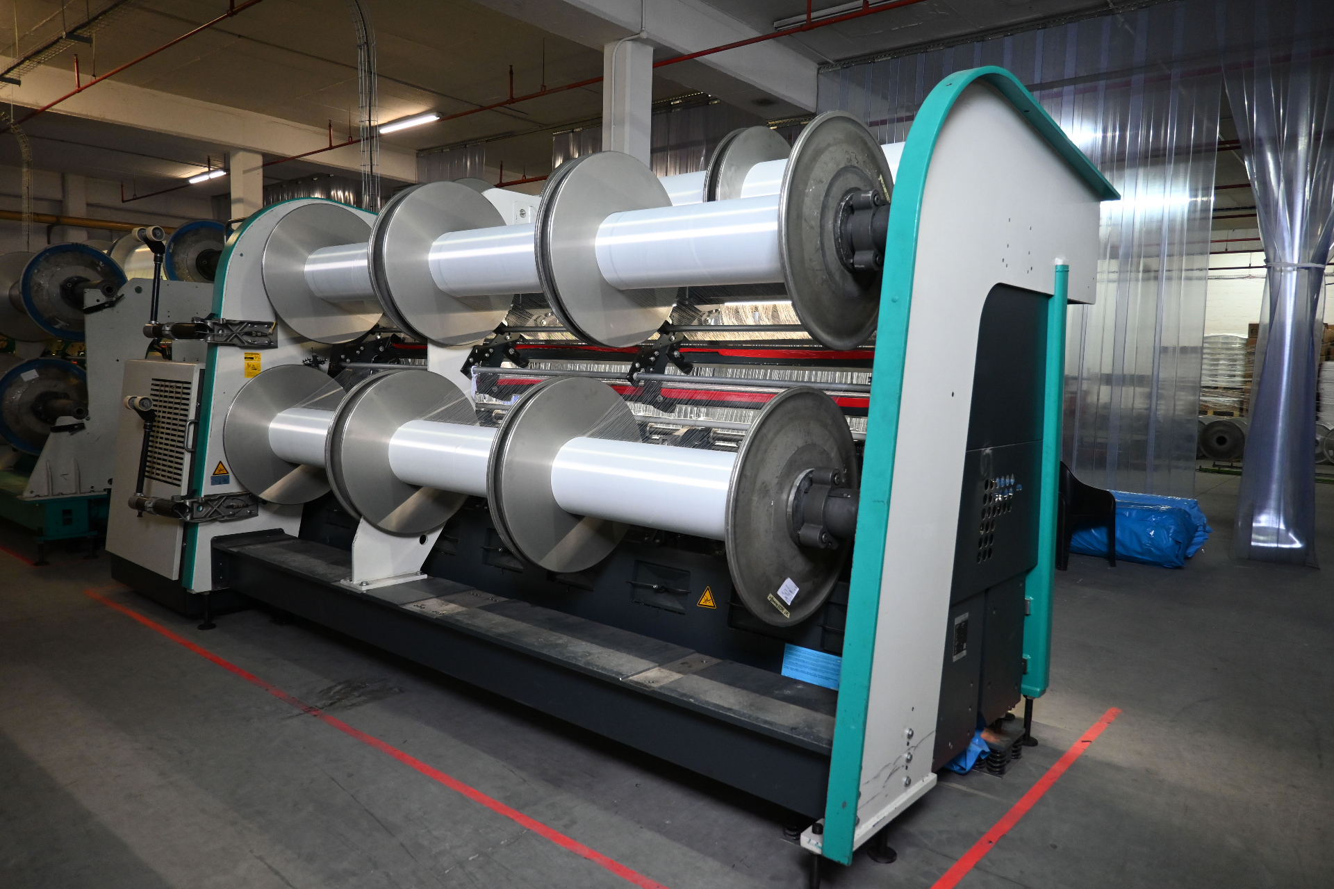Karl Mayer warp-knit machine with beam rolls of polyester yarn
