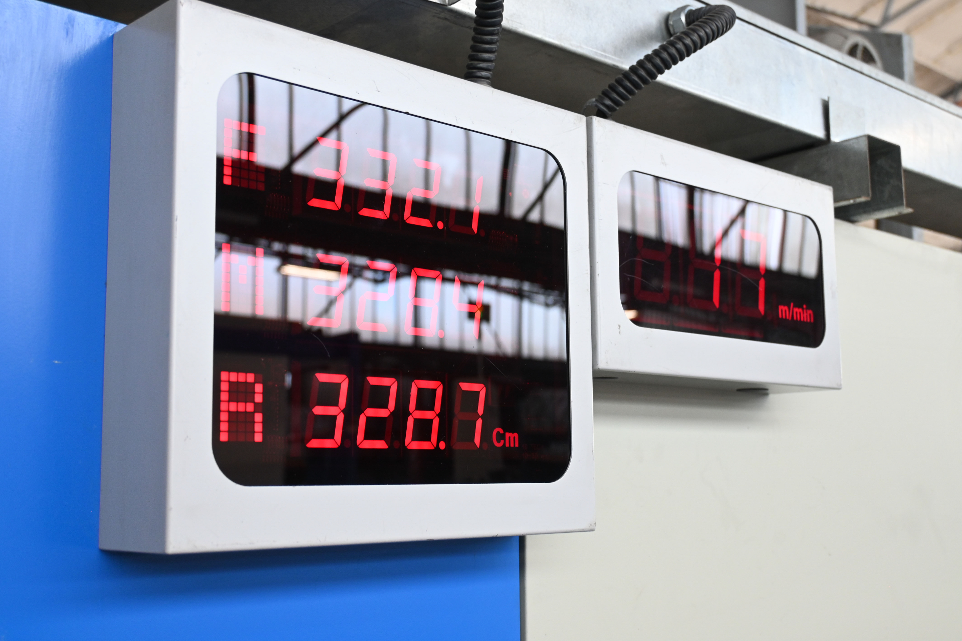 Digital production counters showing fabric length in centimetres and metres per minute