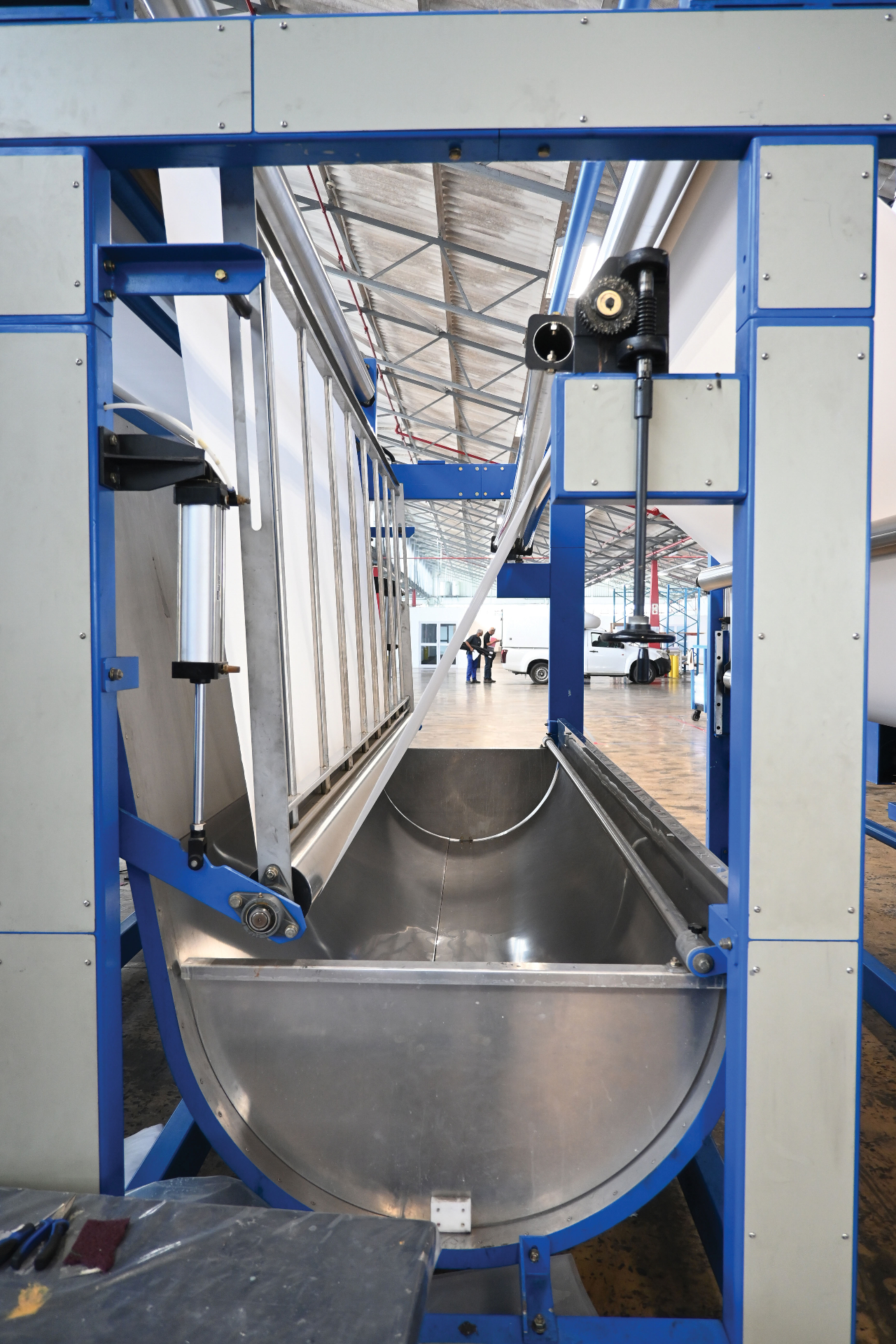 Stainless steel J-box accumulator on the finishing line with blue framework